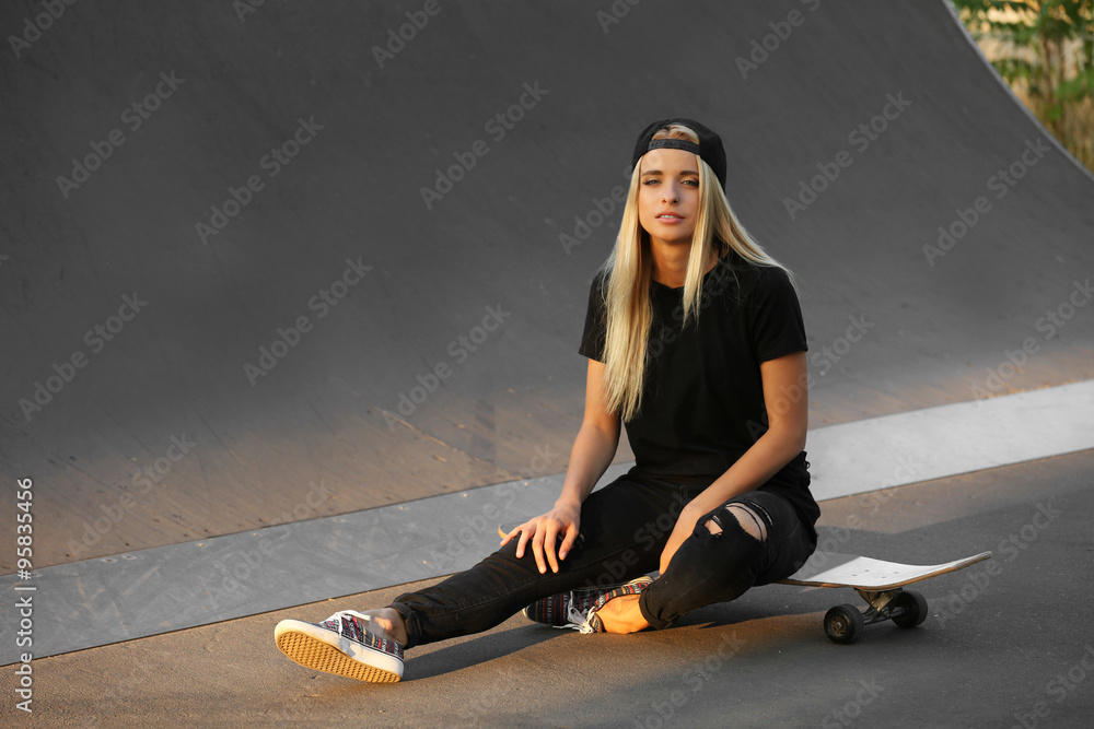 Young woman with skating board on the road