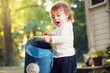 Happy toddler girl playing with watering cans