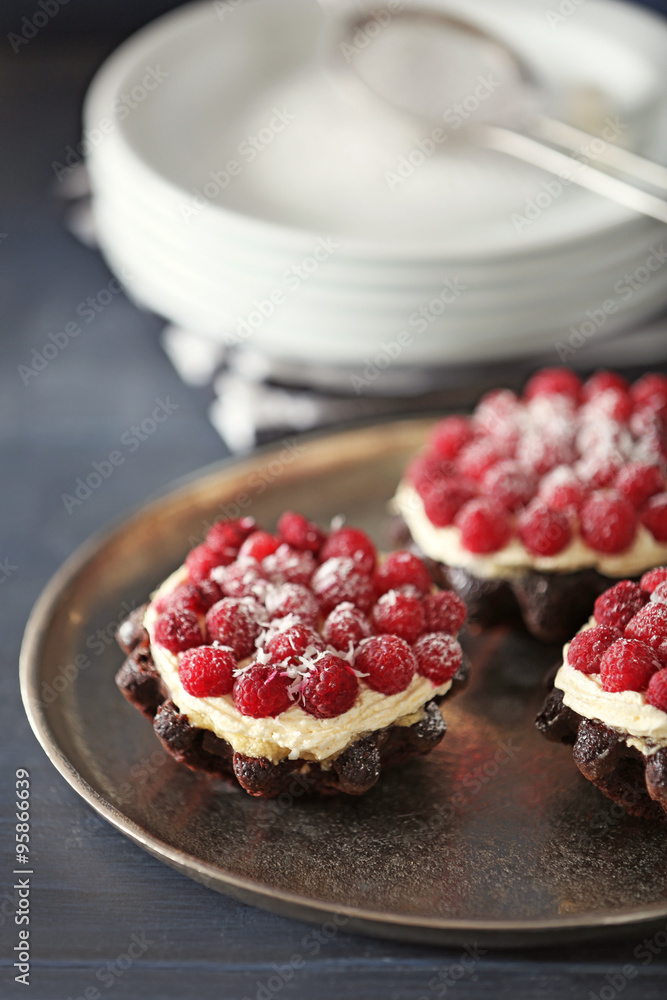 Sweet cake with raspberries on color wooden background