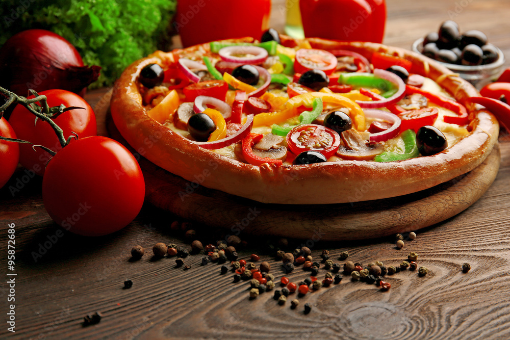 Delicious pizza with vegetables, on wooden table