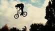 Silhouette of jumper, performing BMX mountain bike sport jump. Slow Motion 400 fps