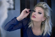 © dexailo - Blonde woman putting on mascara