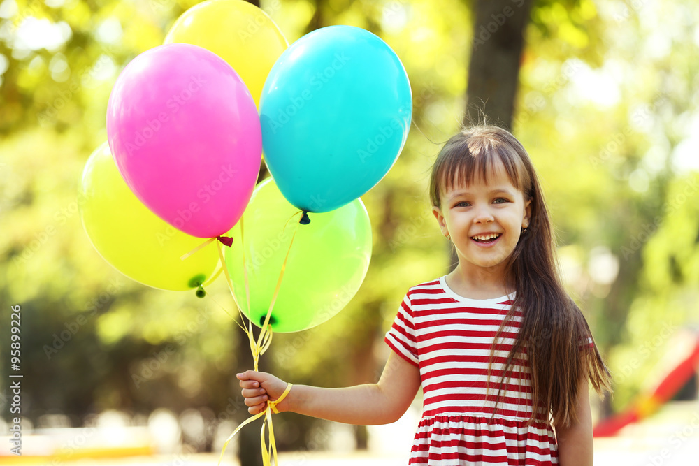 Little girl with balloons in the park