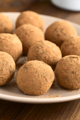 Wall Mural - Homemade rum balls covered with cocoa powder, photographed with natural light (Selective Focus, Focus on the first ball)