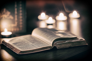 Wall Mural - Bible with candles in the background.