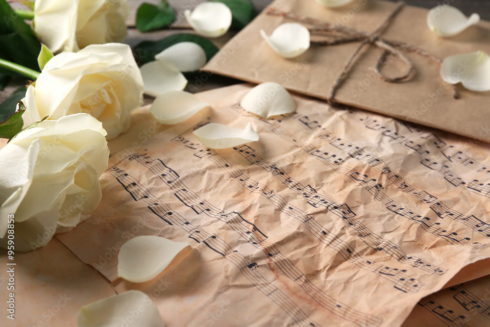Beautiful rose on music sheets background