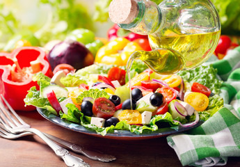 Canvas Print - olive oil pouring into plate of greek salad