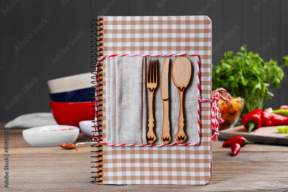 Recipe book and ingredients for cooking on a table in kitchen