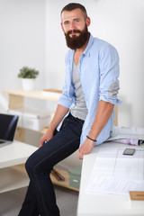 Wall Mural - Portrait of male designer in hat with blueprints at desk 