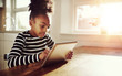 © Flamingo Images - Young black girl browsing on a tablet-pc
