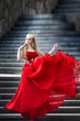 © olenakucher - Queen in red dress standing on the stairs