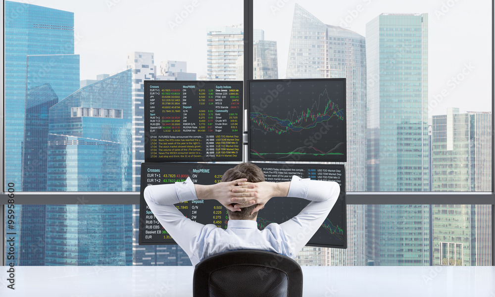 A rear view of relaxing trader who is waiting for a success of his position in front of trading station. Trading at forex market. Singapore panoramic view.