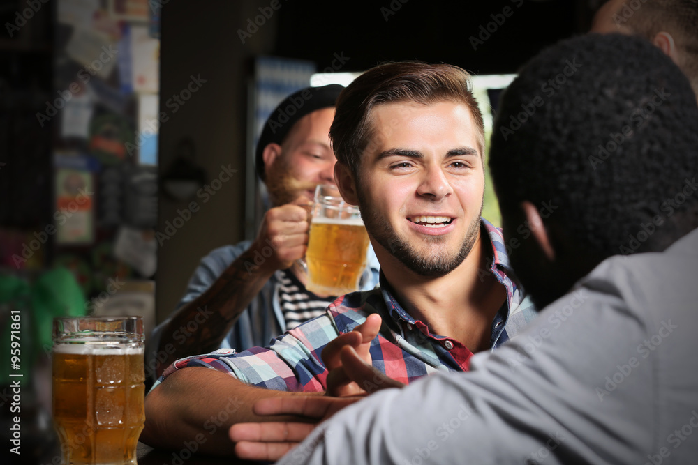 Young men drinking beer in pub