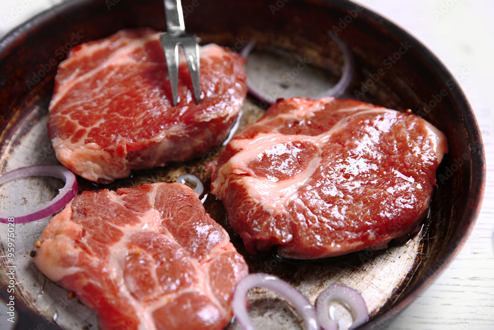 Marbled beef steak on pan and spices on color wooden background
