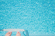 Feet about to climb down ladder into a sparkling pool