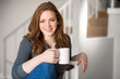 © elnariz - Beautiful female relaxed with cup of tea coffee indoor blonde head shot space modern interior living staircase