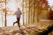 Man running in park at autumn morning