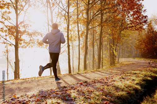Fotomural Man running in park at autumn morning
