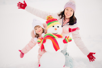 Canvas Print - Family and snowman in winter park