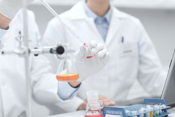 Poster - close up of scientists filling test tube in lab