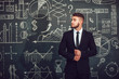 © kanashkin - A bearded man in a suit standing near whiteboard with graphs