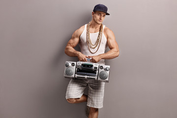 Canvas Print - Young man in hip-hop clothes holding a radio