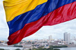 Colombian flag waving on the wind and modern Cartagena district 