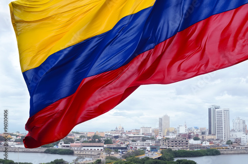 Fotografía Colombian flag waving on the wind and modern Cartagena district