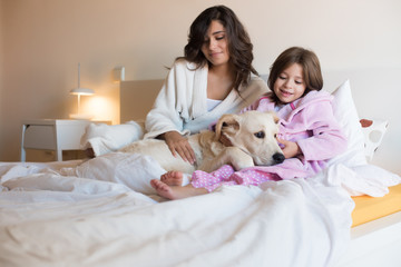 Wall Mural - mother and daughter with dog in bed