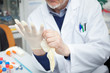 © Minerva Studio - Scientist putting on a glove