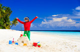 Fototapeta Morze - happy little boy with built sandcastle on beach