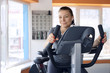© Himchenko - happy woman is engaged on a stationary bike