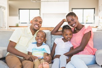 Wall Mural - Portrait of a family of four watching tv