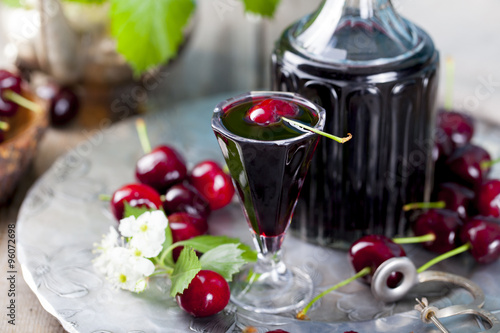 Fotografie, Obraz Cherry homemade liquor in a vintage bottle with fresh cherries.