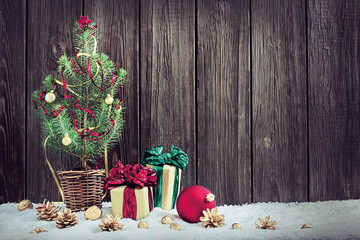 Christmas background with young Christmas tree and small gift bo