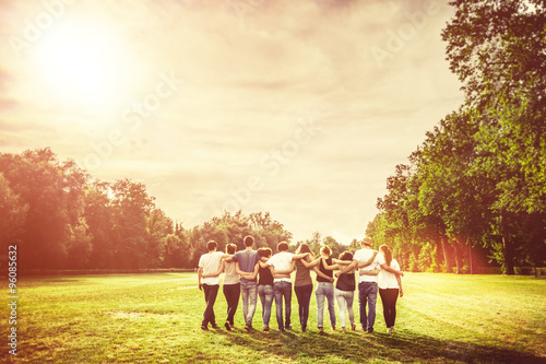 Plakat Grupa nastoletnich przyjaciół w parku o zachodzie słońca