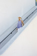 © Mint Images - Blond woman wearing a hat walking down a staircase.