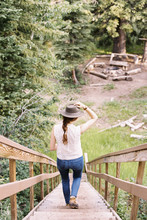 High Angle View Of A Woman Walking Down A Steep Wooden Staircase.