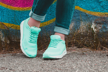 Canvas Print - Peppermint sneakers on girl legs on the graffiti background