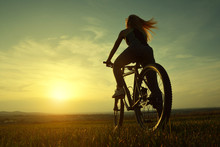 Girl On A Bicycle In The Sunset