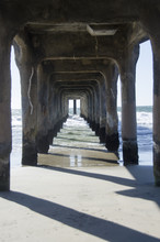 Under The Pier At The Beach With The Posts Or Columns.