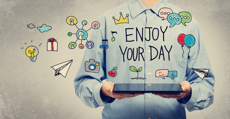 Wall Mural - Enjoy Your Day concept with young man holding a tablet