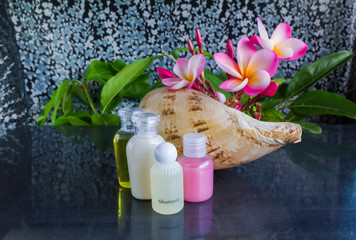 Wall Mural - Mini set of bubble bath and shower gel in sea conch shell  decorated with beautiful flower plumeria 