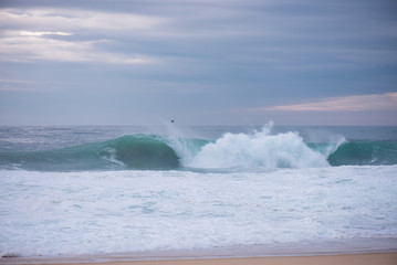 Wave crashing on a coast in Nazare, Portugal.