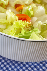 Mediterranean green salad detail with lettuce and tomato in a bo