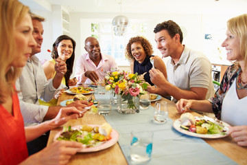 Wall Mural - Mature Friends Sitting Around Table At Dinner Party