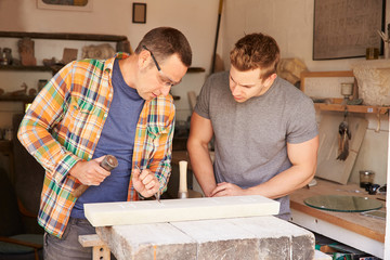 Wall Mural - Stone Mason With Apprentice At Work On Carving In Studio