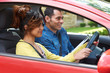 Young Woman Having Driving Lesson With Instructor
