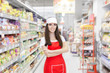 Smiling Supermarket Employee Standing Among Shelves - Portrait of a young sales clerk in a market store 

