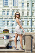 © Andrey_Arkusha - Young beautiful woman in beige short dress posing outdoors in su